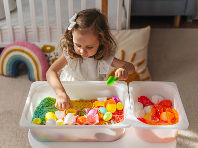 Toddler girl playing with colorful sand and toys Toddler girl playing with colorful sand and toys