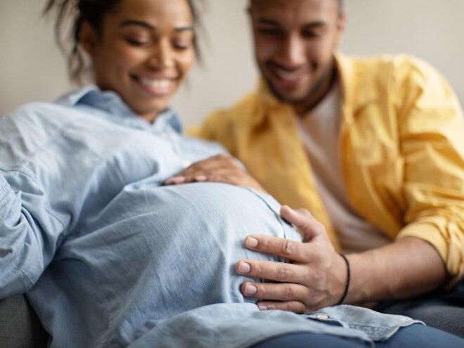 Pregnant woman and her partner holding her pregnant belly Pregnant woman and her partner holding her pregnant belly