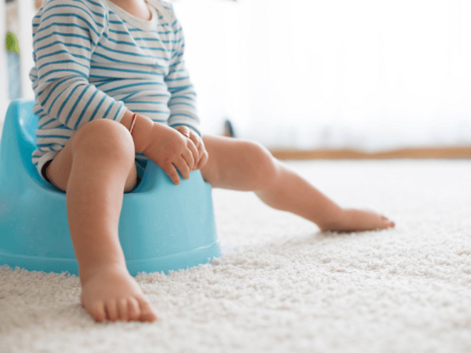 Toddler Constipation Toddler in bodysuit sitting on a blue potty