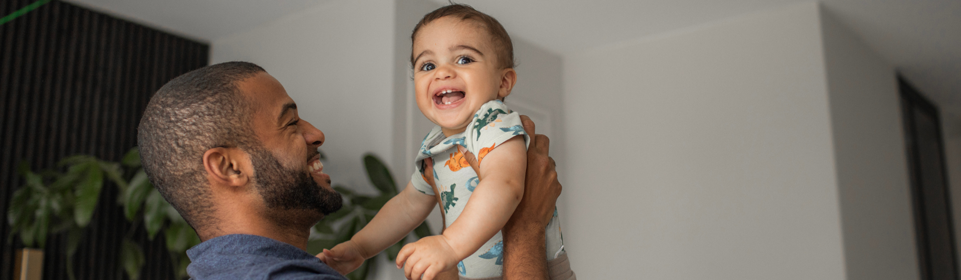Father holding toddler in the air and laughing Father holding toddler in the air and laughing