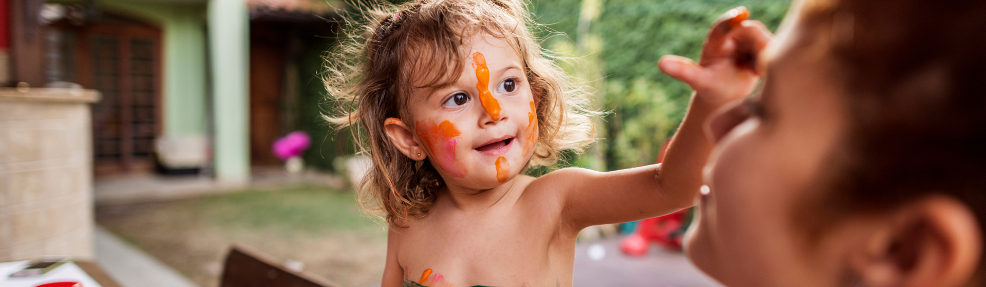 Preschooler with painted face painting mothers face Preschooler with painted face painting mothers face