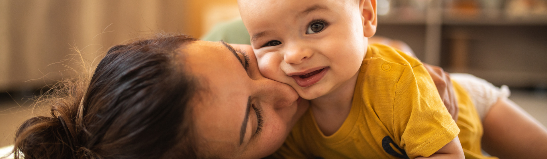 Mother and baby in yellow onesie playing together Mother and baby in yellow onesie playing together