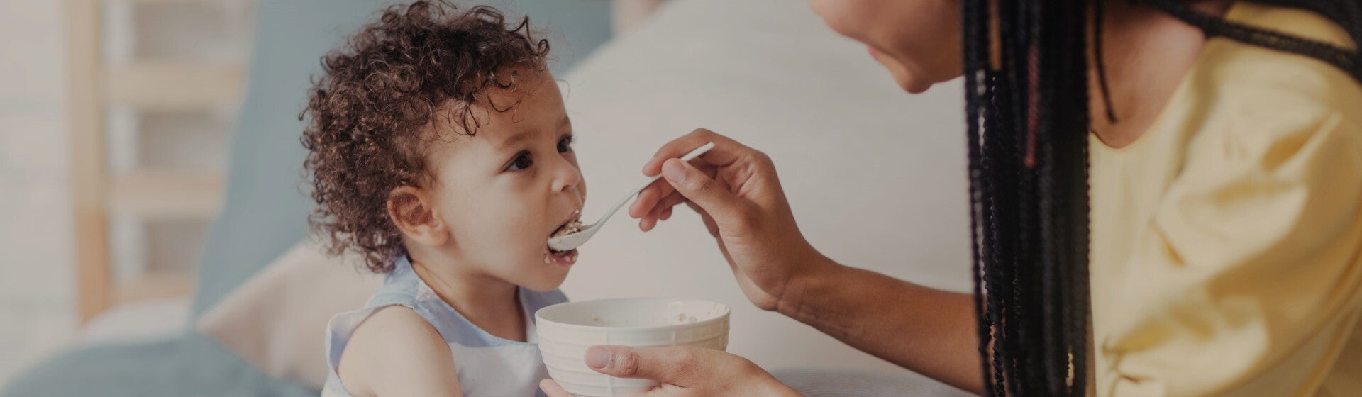 mother feeding child with spoon mother feeding child with spoon