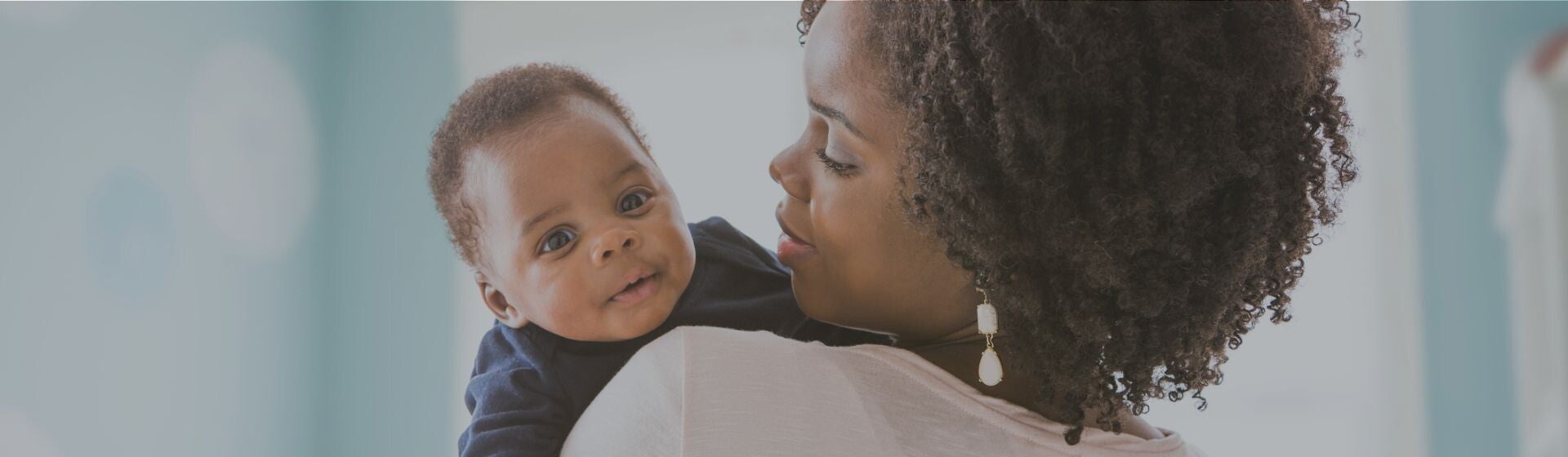 Woman in white tshirt with her baby looking over her shoulder Woman in white tshirt with her baby looking over her shoulder