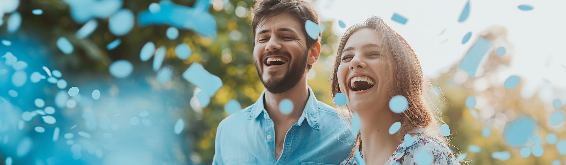 Couple smiling with blue confetti Couple smiling with blue confetti