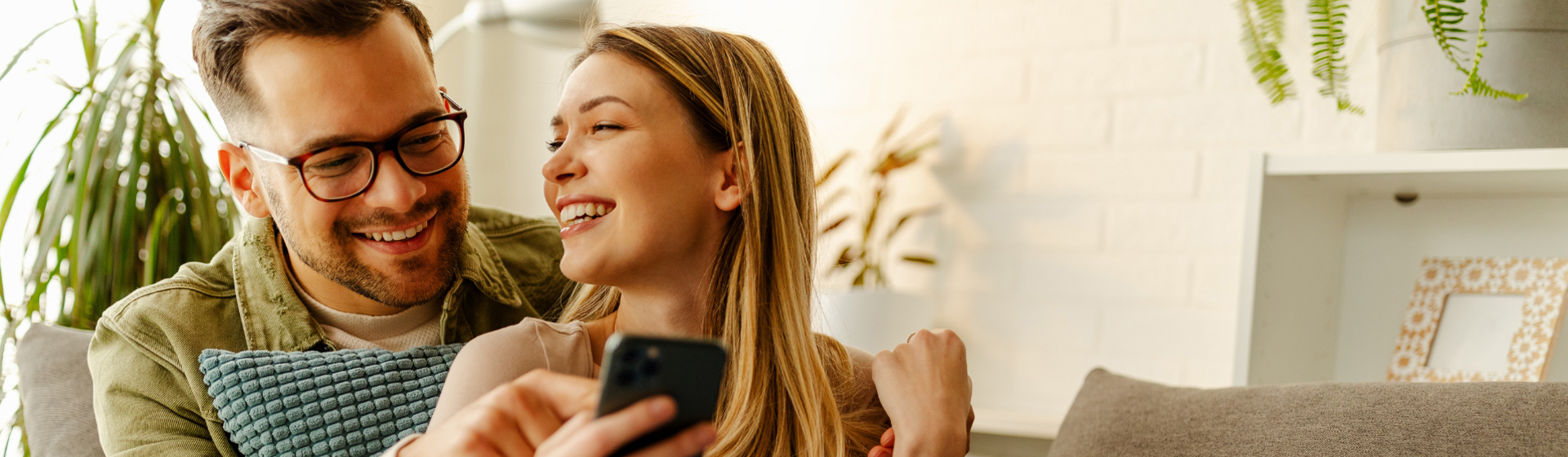Couple looking at their mobile phone smiling Couple looking at their mobile phone smiling
