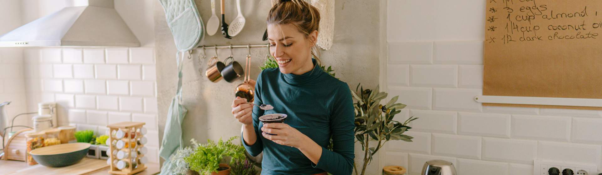 Woman in green shirt eating food in her kitchen Woman in green shirt eating food in her kitchen