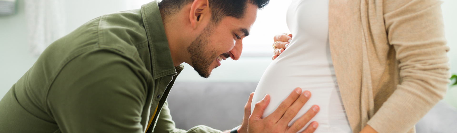Man hugging womans pregnant stomach Man hugging womans pregnant stomach
