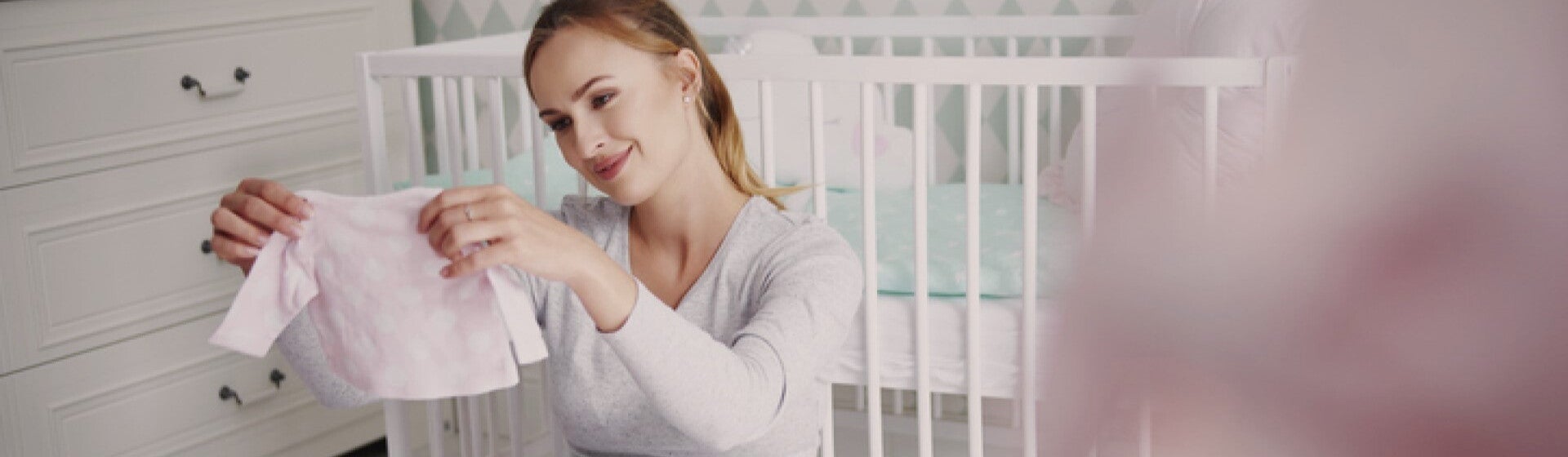pregnant woman looking at newborn clothes pregnant woman looking at newborn clothes