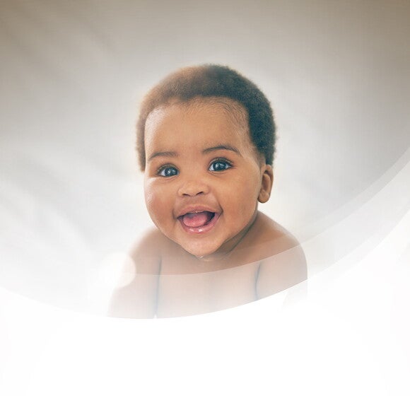 Smiling toddler with a dark grey background Smiling toddler with a dark grey background